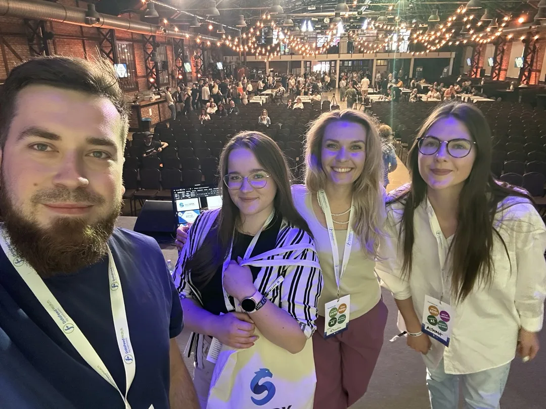 Specjaliści Up Blue z identyfikatorami konferencji semKRK#23 BIG robią wspólne zdjęcie w sali Starej Zajezdni w Krakowie